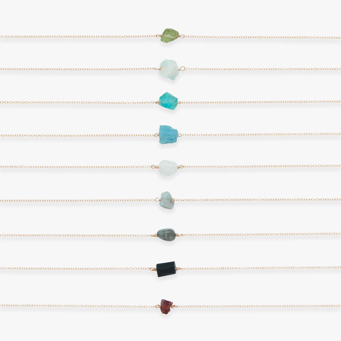 Set of gold necklaces with various colored beads on a white background