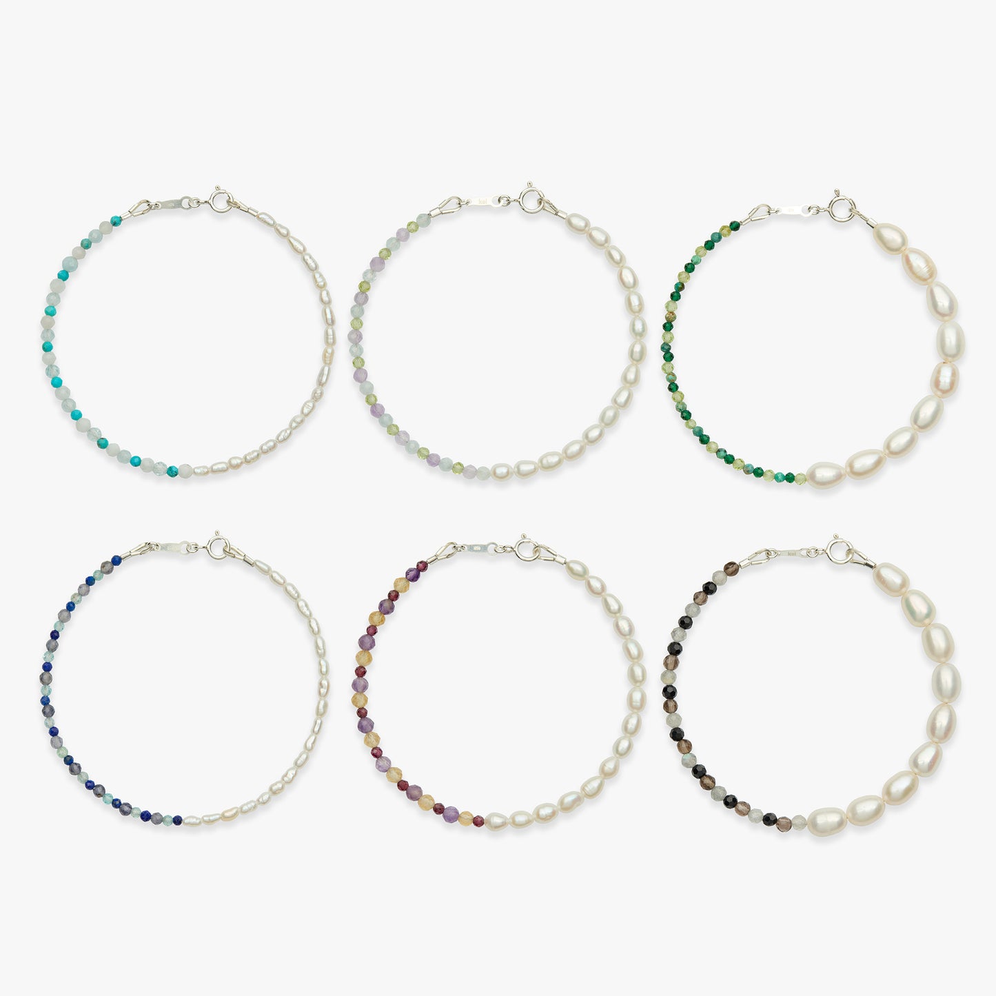 Six pearl chain bracelets arranged in two rows on a light gray background. Each bracelet has a silver-tone chain and one end decorated with small faceted beads in different colors: turquoise, iridescent, green, blue, purple, and dark brown.