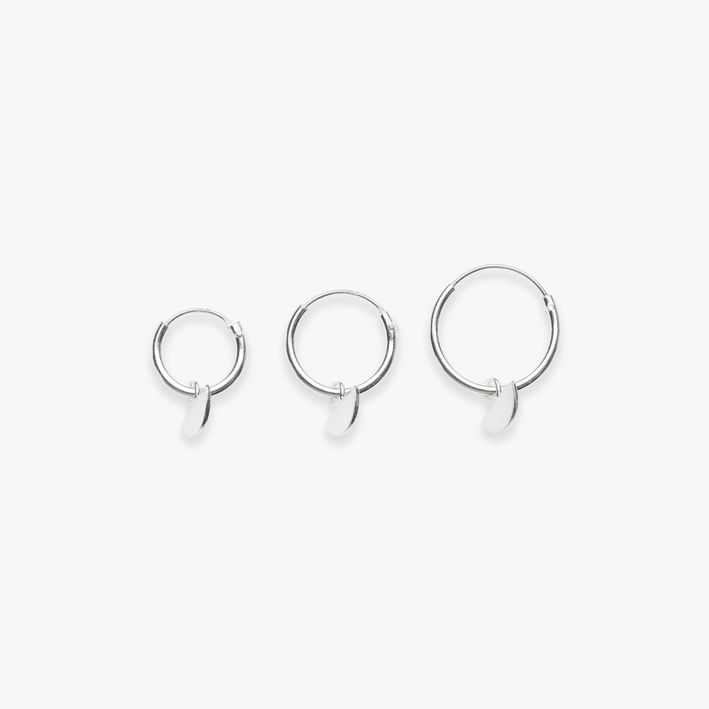 Three silver hoop earrings on a white background
