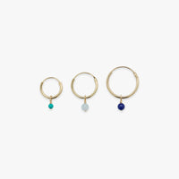 Three gold hoop earrings with colored beads on a white background