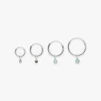 Four silver hoop earrings with gemstone drops on a white background