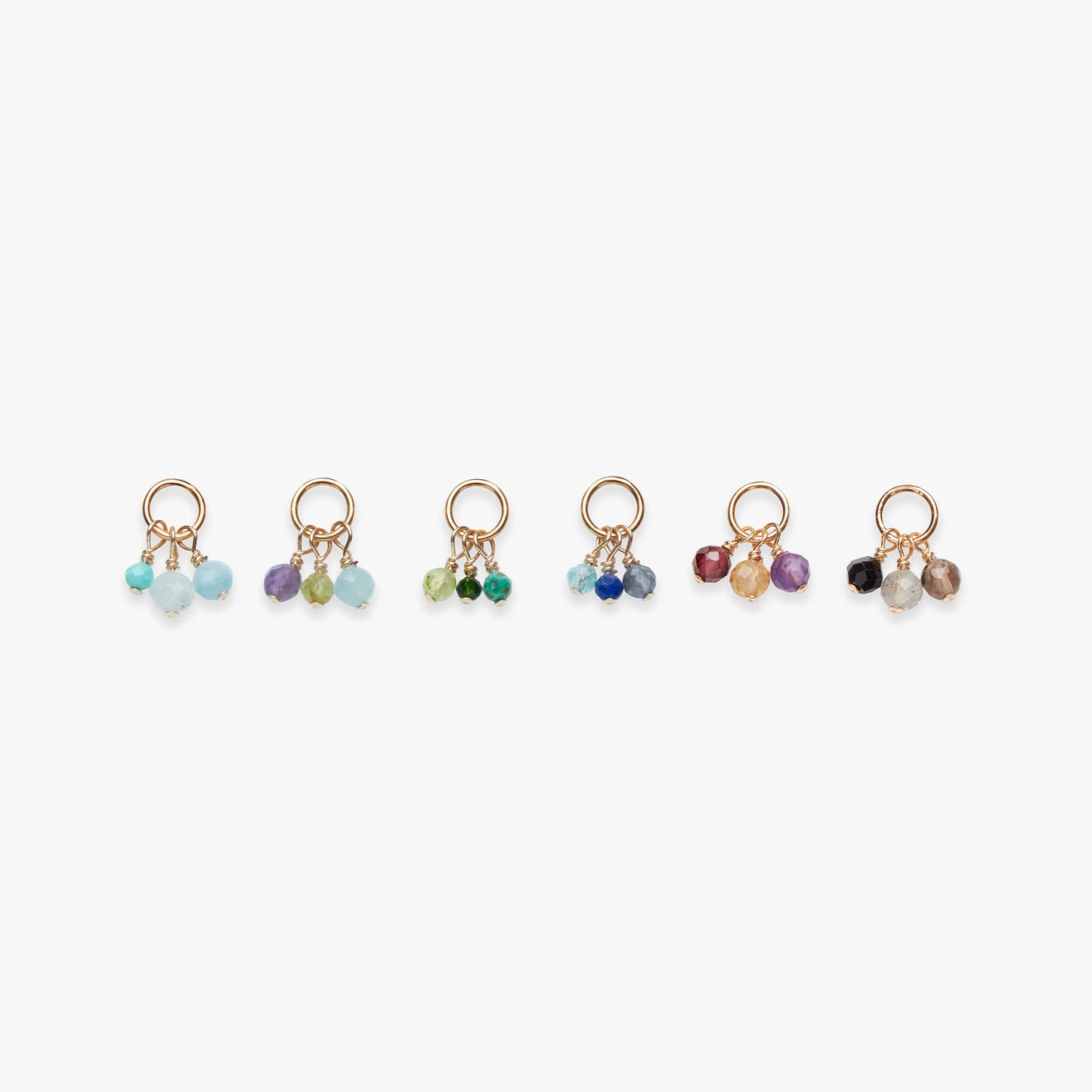 Set of six gold studs with multicolored beads on a white background