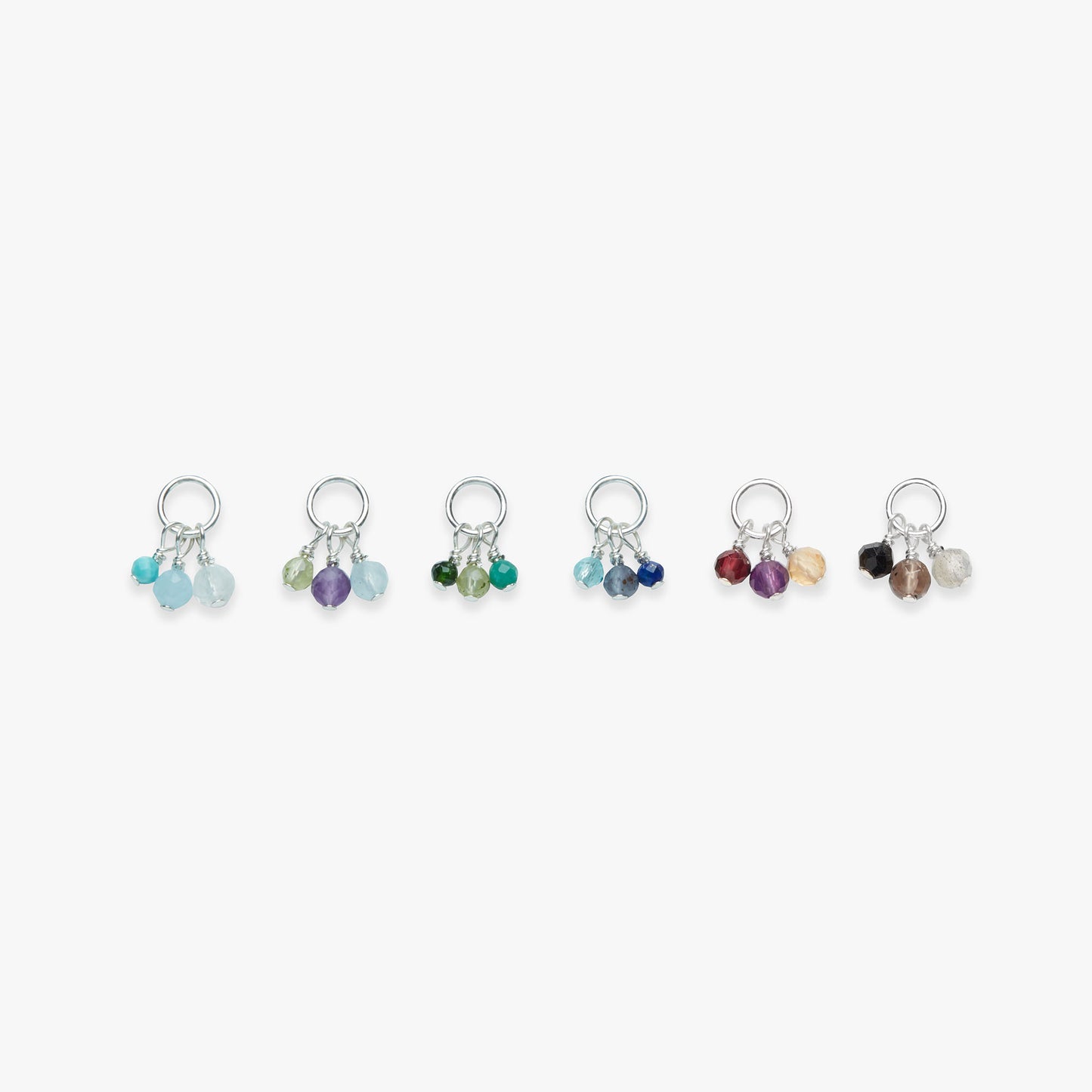Set of six colorful silver stud earrings on a white background