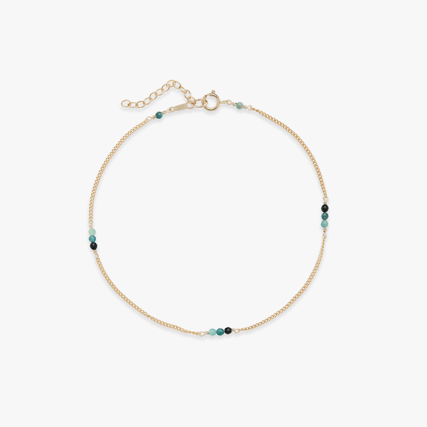 Gold anklet with blue beads on a white background