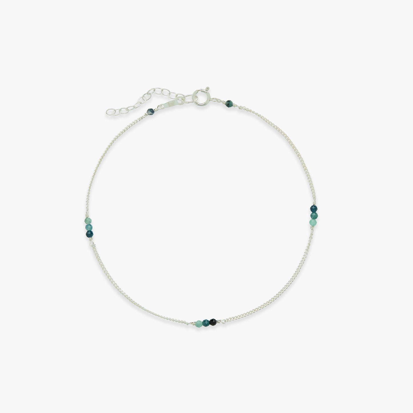 Silver anklet with small blue beads on a white background