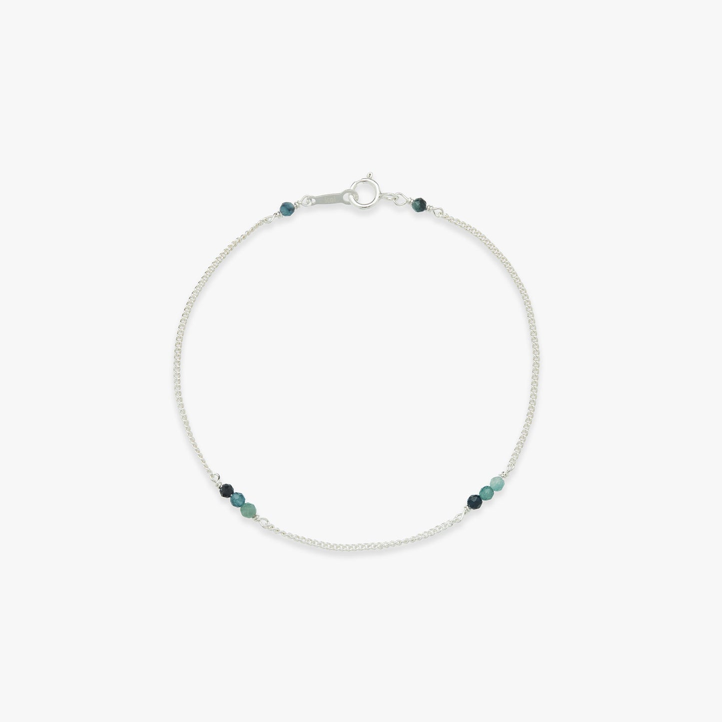 Silver bracelet with small blue beads on a white background