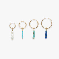 Set of four hoop earrings with bead accents on a white background
