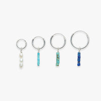 Set of four hoop earrings with bead accents on a white background