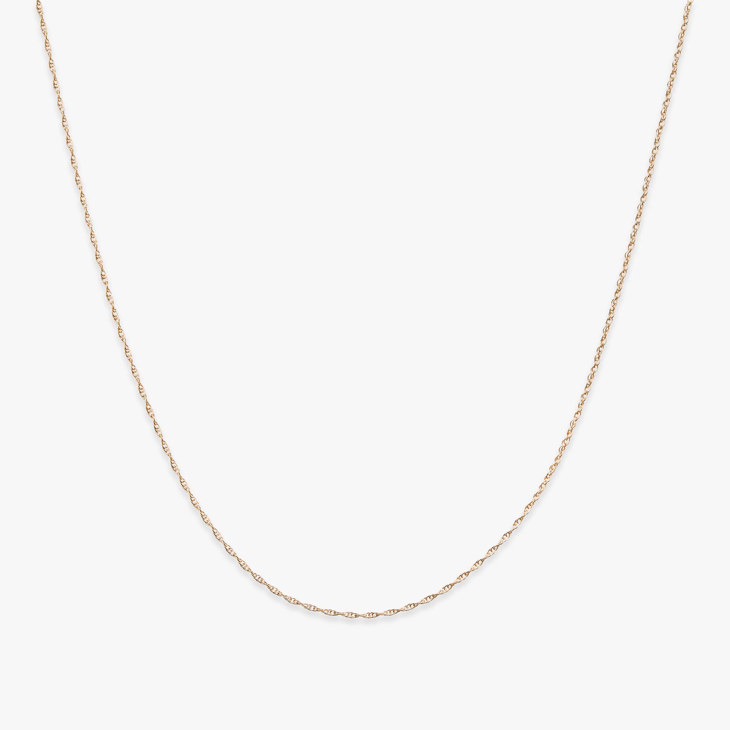 Gold rope chain necklace on a white background