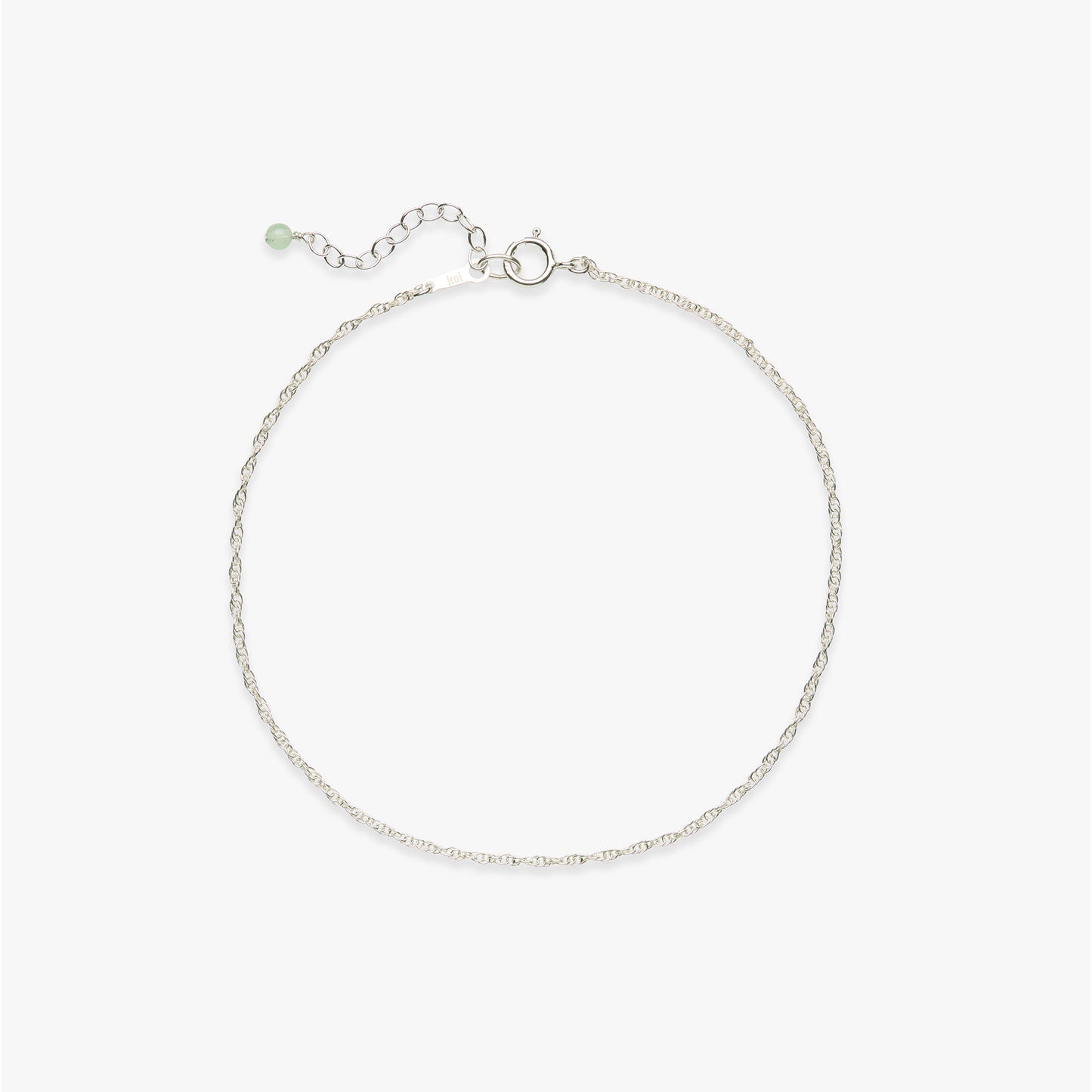 Silver rope chain anklet with a gemstone detail on a white background