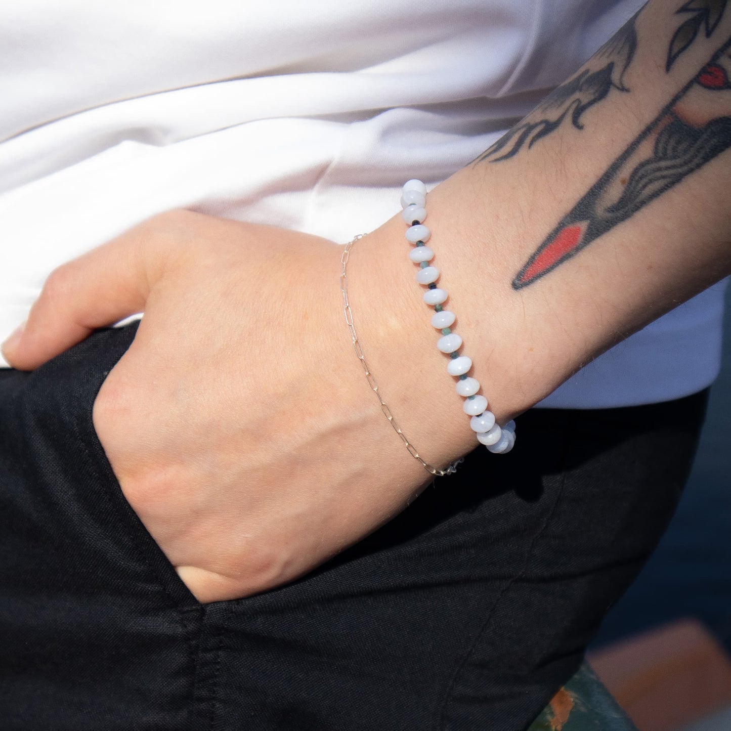 Person wearing a bracelet with a tattoo on their arm