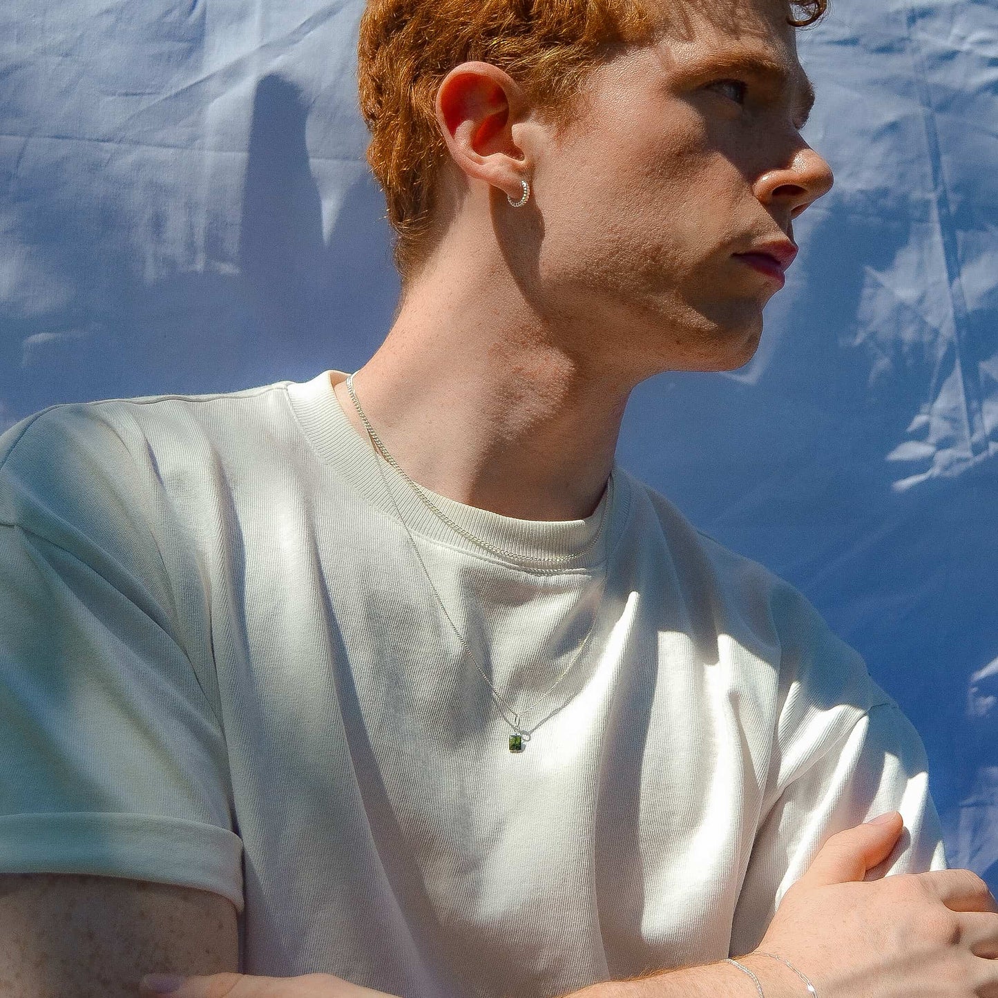Person wearing a white t-shirt with a blue background