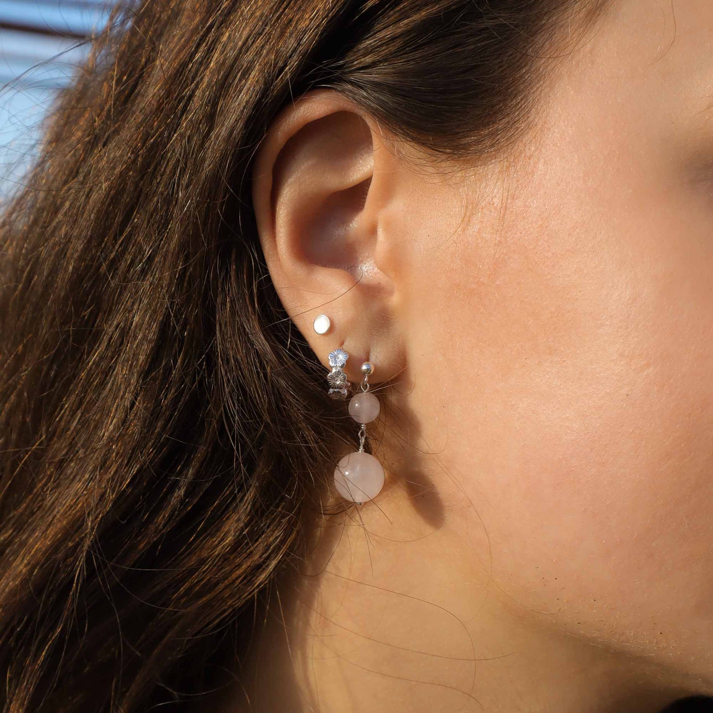 Close-up of a person wearing earrings with a blurred background