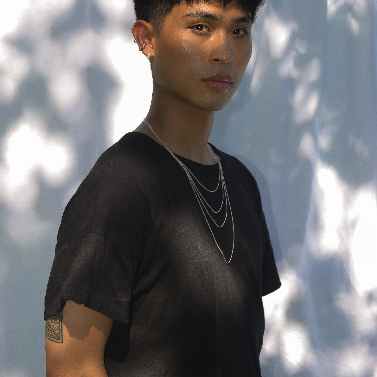 Person wearing a black shirt with a blurred natural background