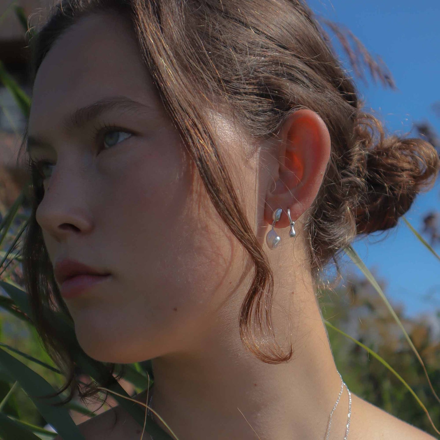 Close-up of a woman with earrings in a natural setting