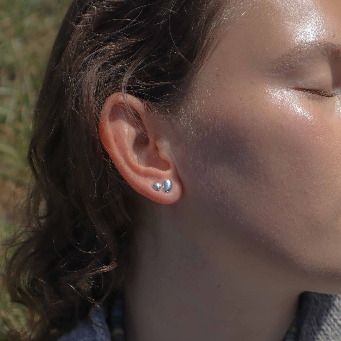 Close-up of a person wearing silver earrings outdoors