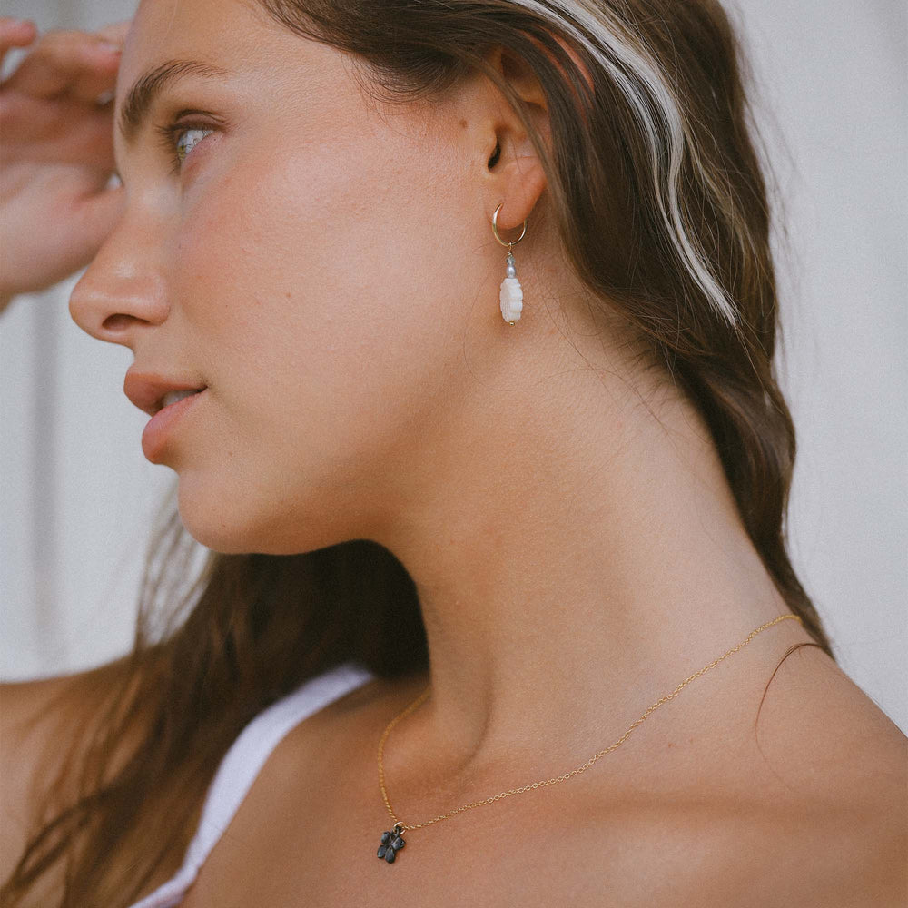 
                  
                    Gouden oorbel en ketting met parelmoer
                  
                